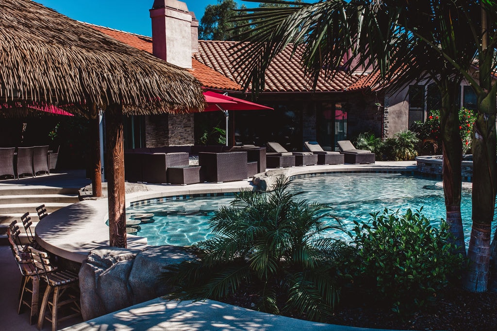 Crystal-clear pool with palapa and palm trees in San Diego, Sol Pacific Pool Plastering
